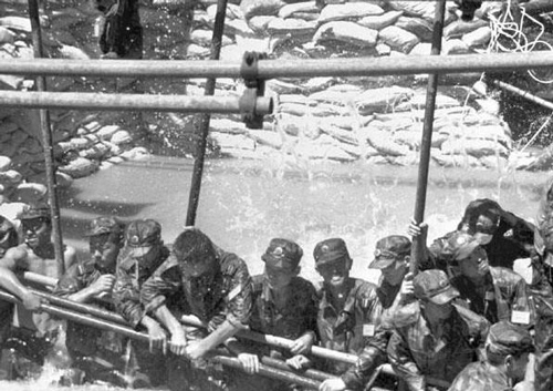 1998年解放军南京军区某部红军团战士在长江大堤决口处用人堤堵住决口