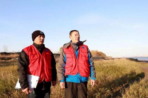 杨金龙（左）和其他观测员一起，观测江面上活动的江豚.png